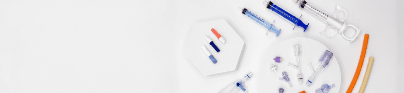 Syringes, tubing and connectors arranged on a white surface